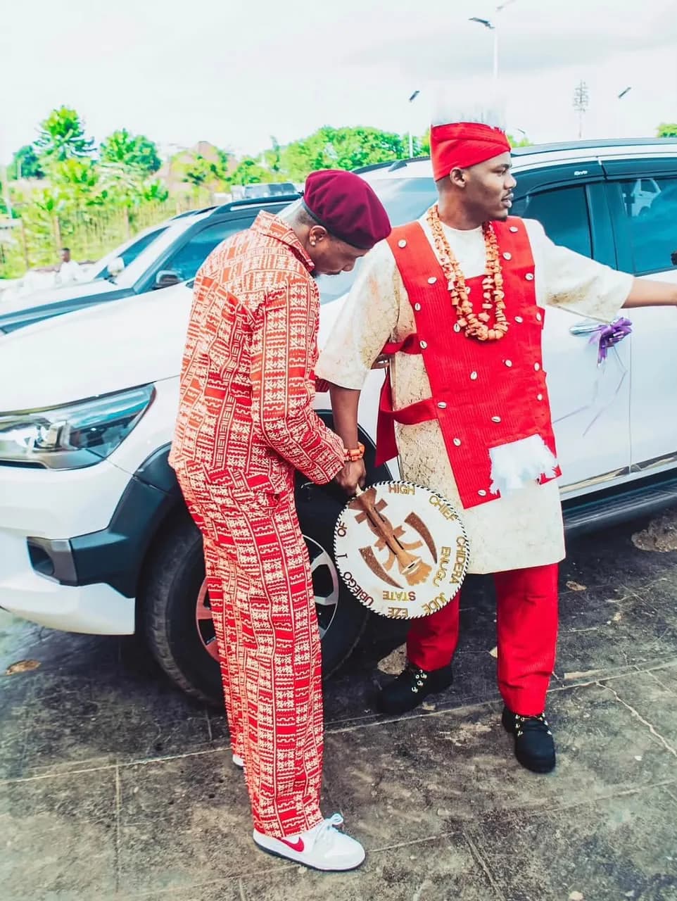 Two clients in red heritage prints beside a white truck
