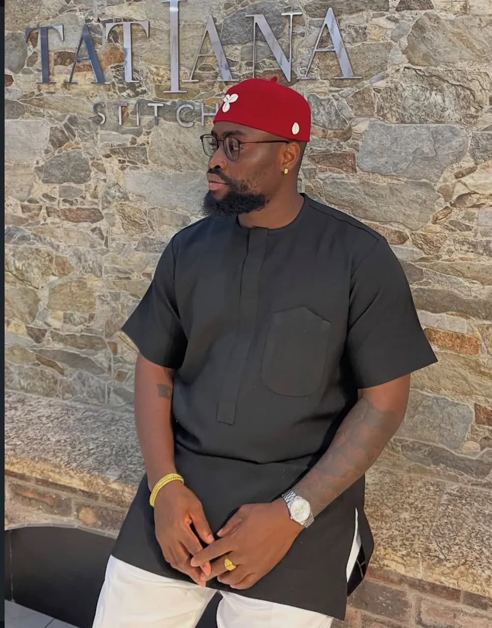Black senator with red cap against the logo wall