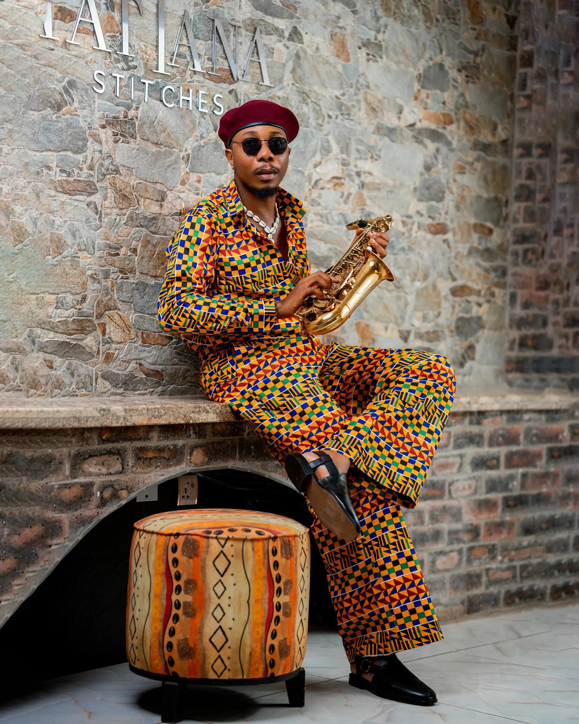 Kente look seated on the stone ledge