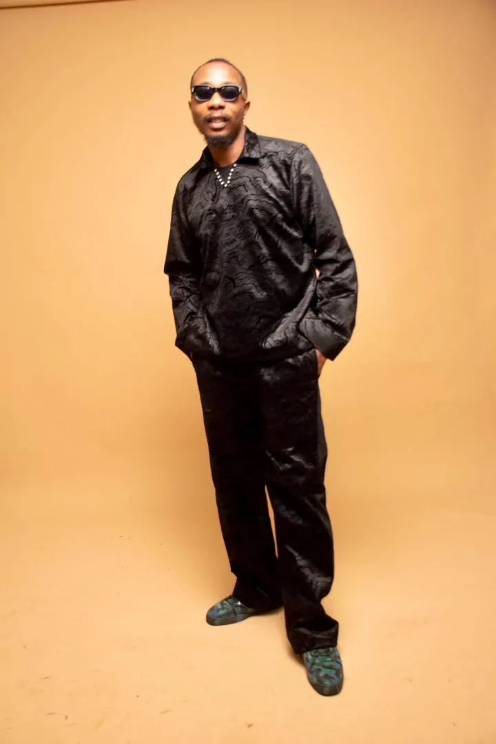 Black silk shirt and trousers on a sand backdrop