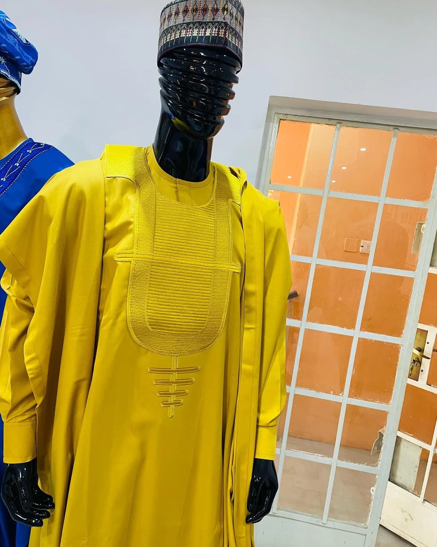 Mustard agbada on a black mannequin